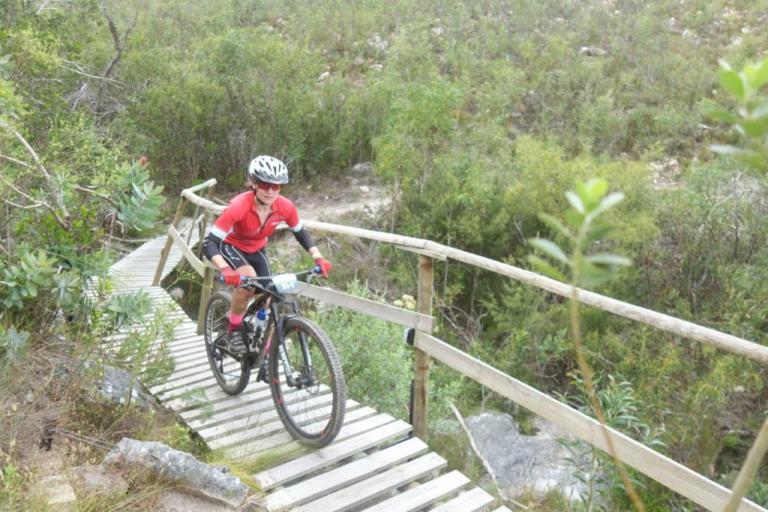 A biker heading over a wooden bridge