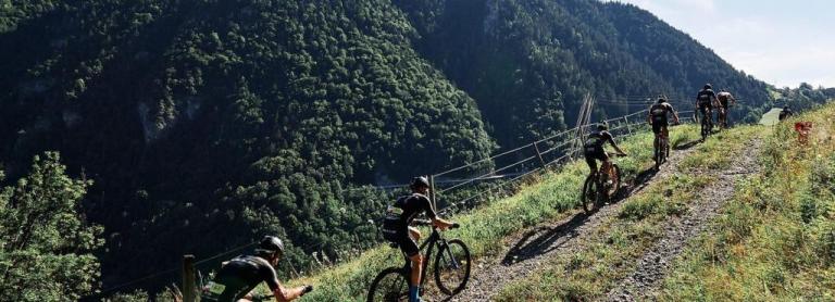 A row of bikers heading up a hill in the Pyrenees Mountains