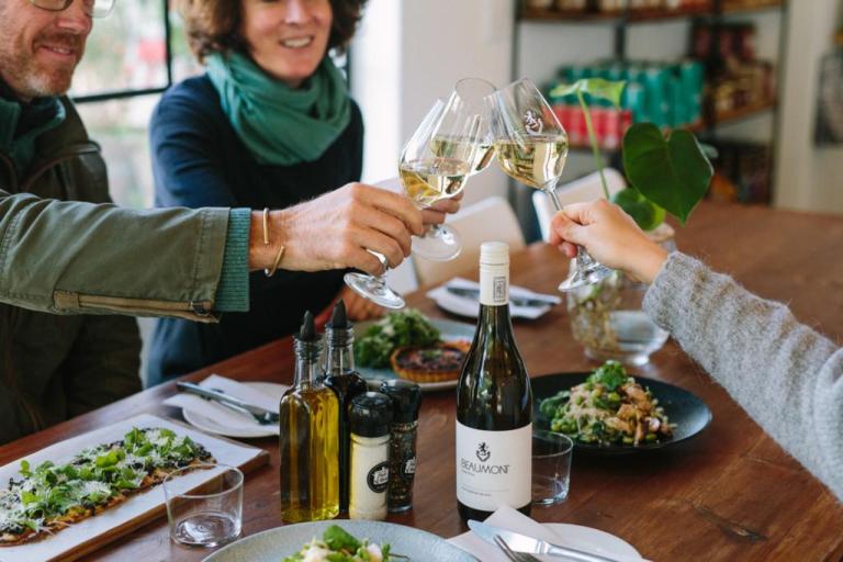 Three people cheers-ing their wine at the Zest Kitchen and Deli