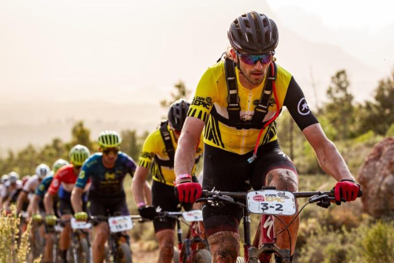 Many bikers peddling uphill in the forest