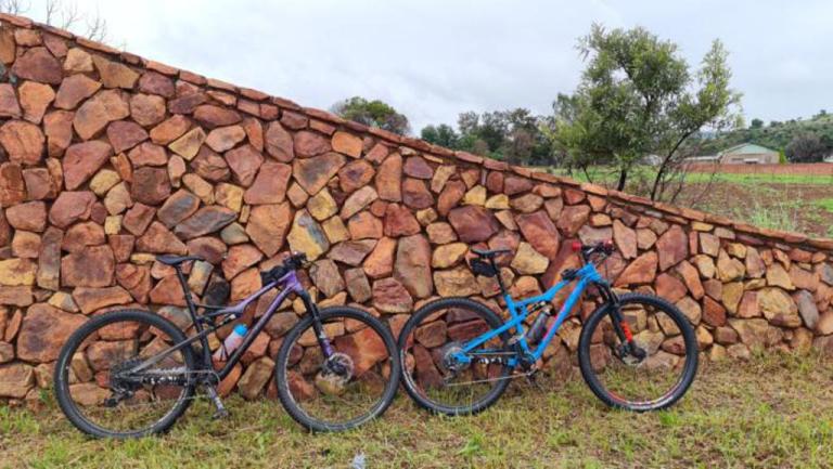 Two bikes laying against a wall