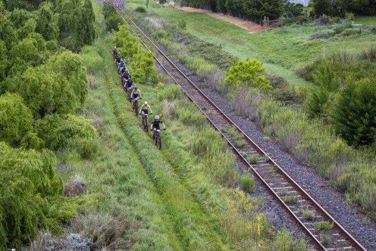 A line of bikers by a railroad
