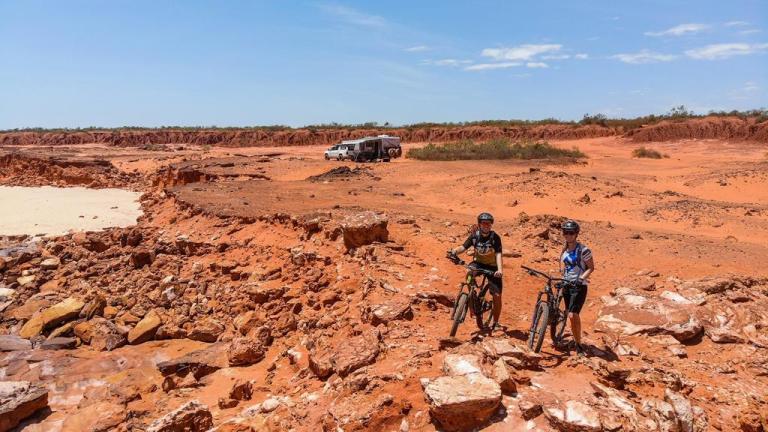 Lehmann and Anson-Smith posing on some dark red clay roads 