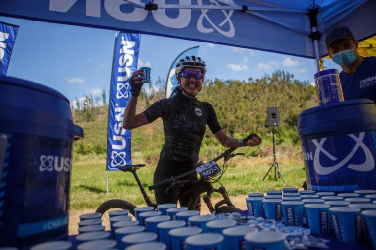 A smiling biker in front of the hydration station