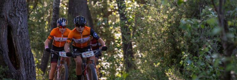 Frei and Stigger biking through thick greenery