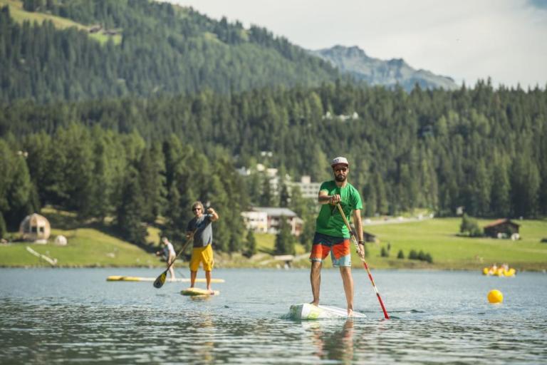 Two bikers paddle boarding in Davos