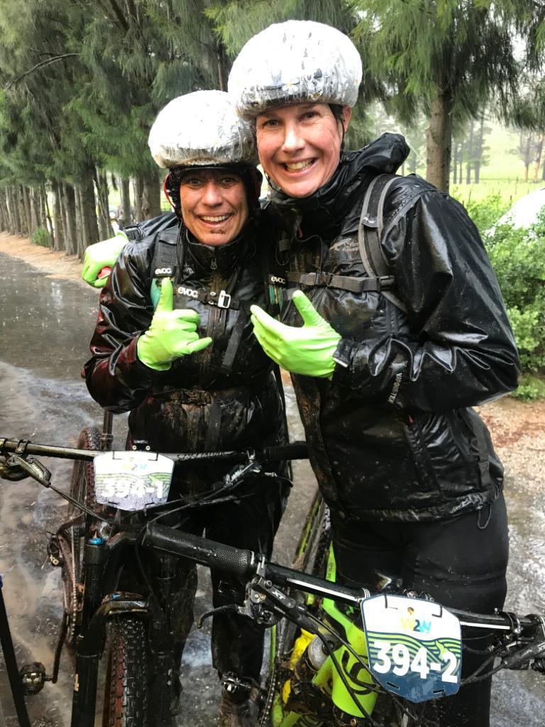Two bikers in rain gear smiling