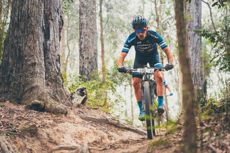 Jon Odams biking through the forest on the Cape to Cape