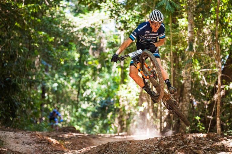 Jon Odams jumping off of a mound of dirt on his bike