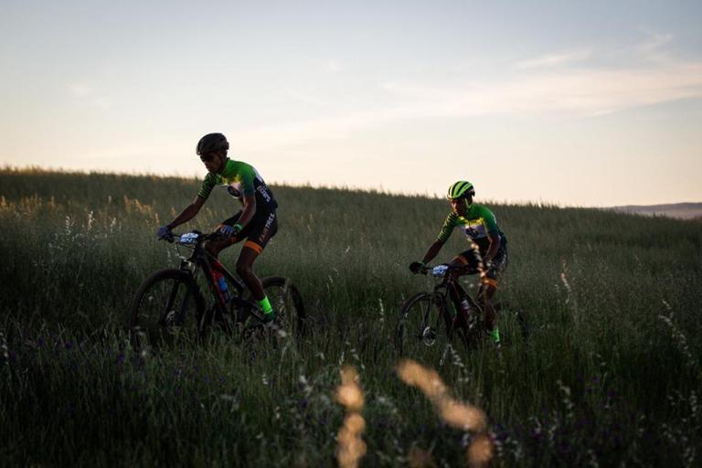 Two bikers heading through a field