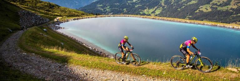 The Pyrenees race with two bikers and a lake in the background