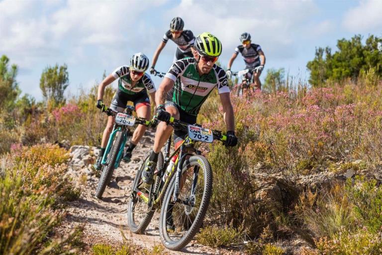 Scott-SRAM team heading down a trail in a meadow