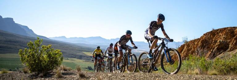 An angled shot of bikers heading up a mountain trail