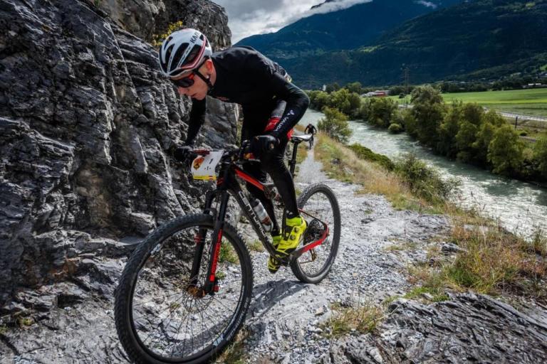 A biker struggling up a steep incline