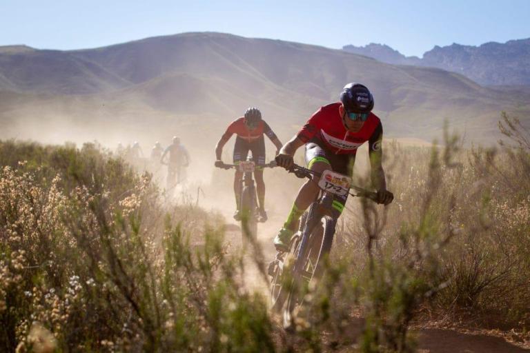 A narrow trail with the bikers stirring up dust
