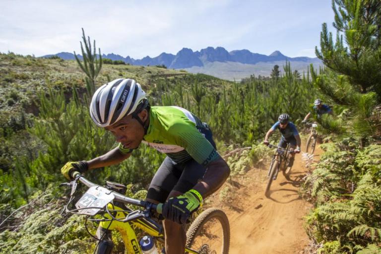 Three bikers heading up a desert path