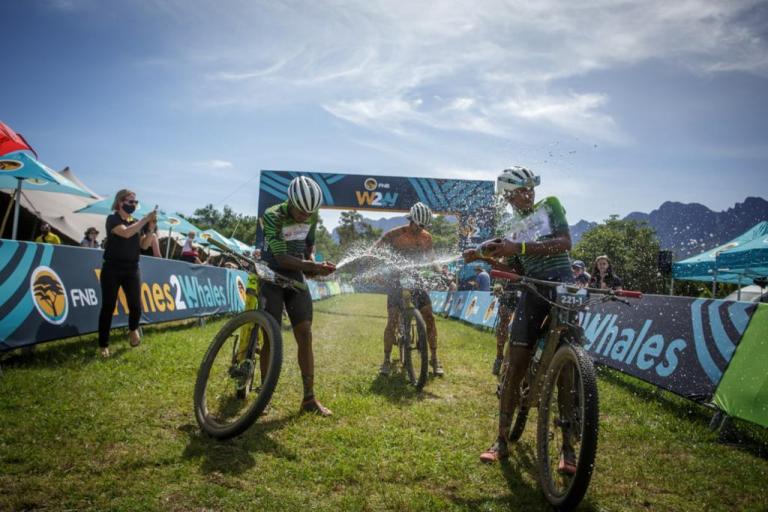 Three bikers spraying champagne on each other after the W2W race