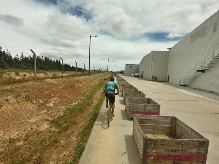 A biker heading by a  bunch of crates