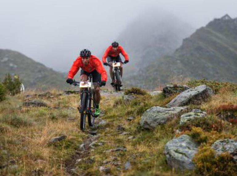 Käss and Geismayr biking through a rocky path
