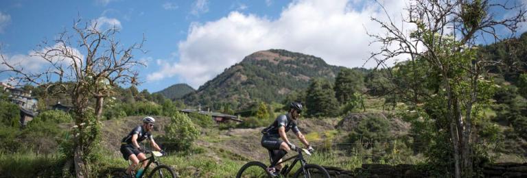 A shot of two bikers with an Andorran background