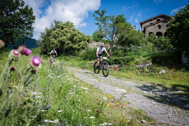 A countryside with two bikers on a stone path