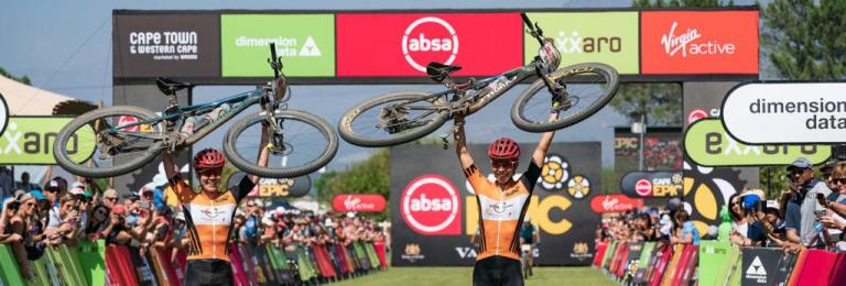 Annika Langvad and partner holding their bikes over their head