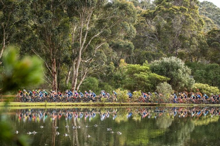 Hundreds of bikers heading across a path near a lake [Cape to Cape]