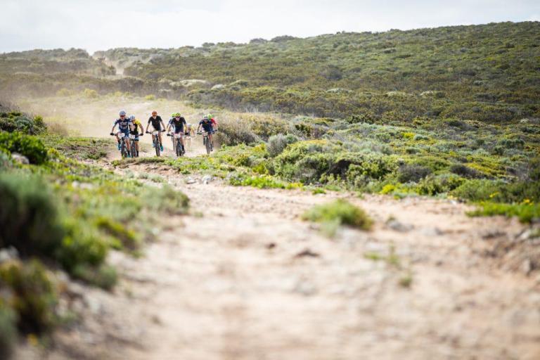 Bikers heading up a dusty trail