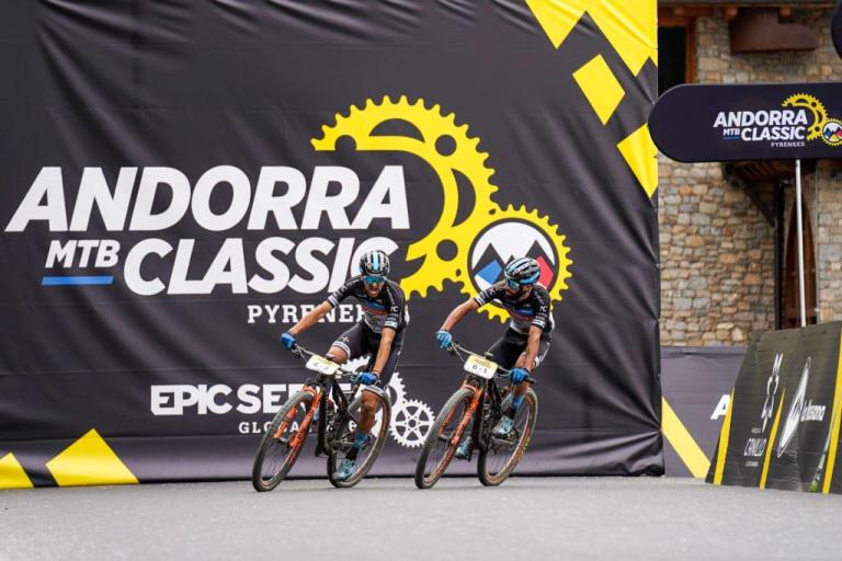 Two bikers rounding the corner of the final turn