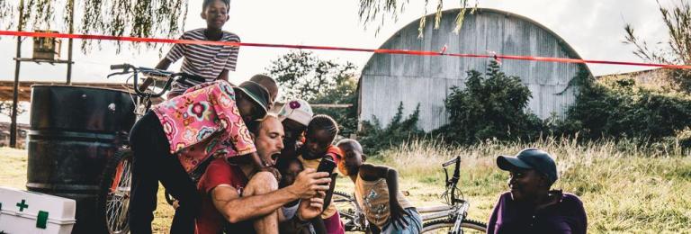A biker showing some some children videos off of his phone