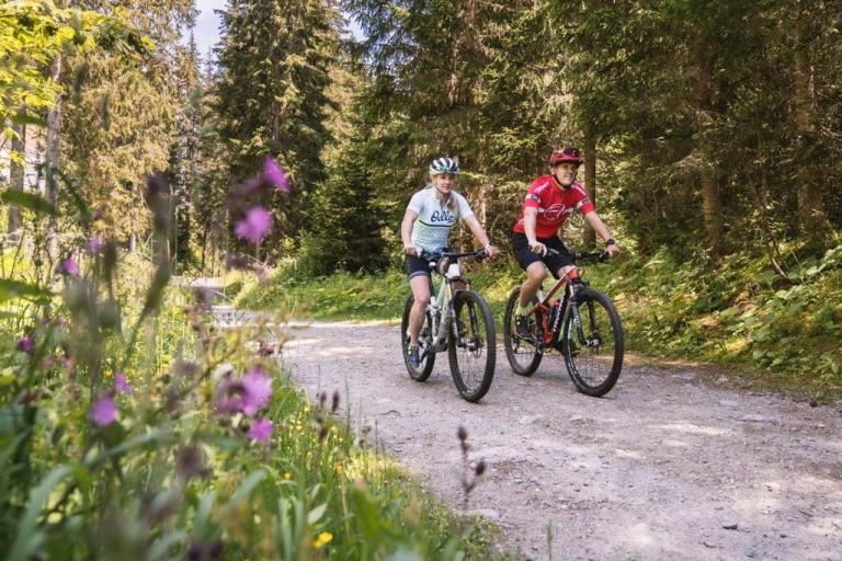 Kaeslin biking with the beautiful forest greenery around her