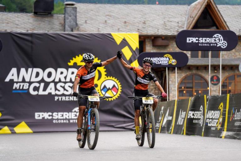 Two bikers high fiving at the final stretch of the andora epic
