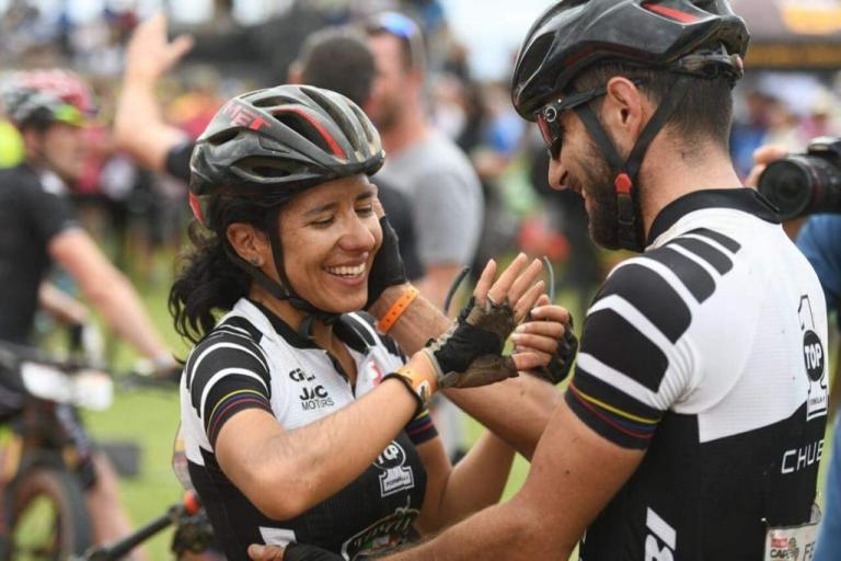 A biker couple holding hands while crossing the Swiss Epic finish line