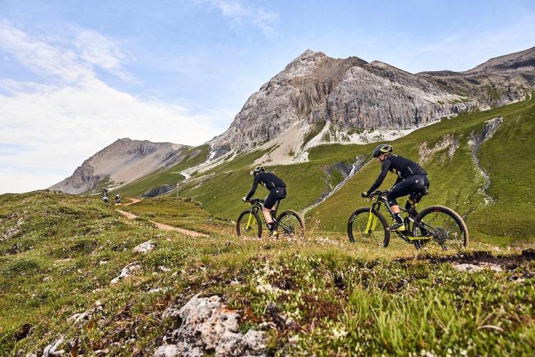 Two bikers biking against the hills of Graubünden 
