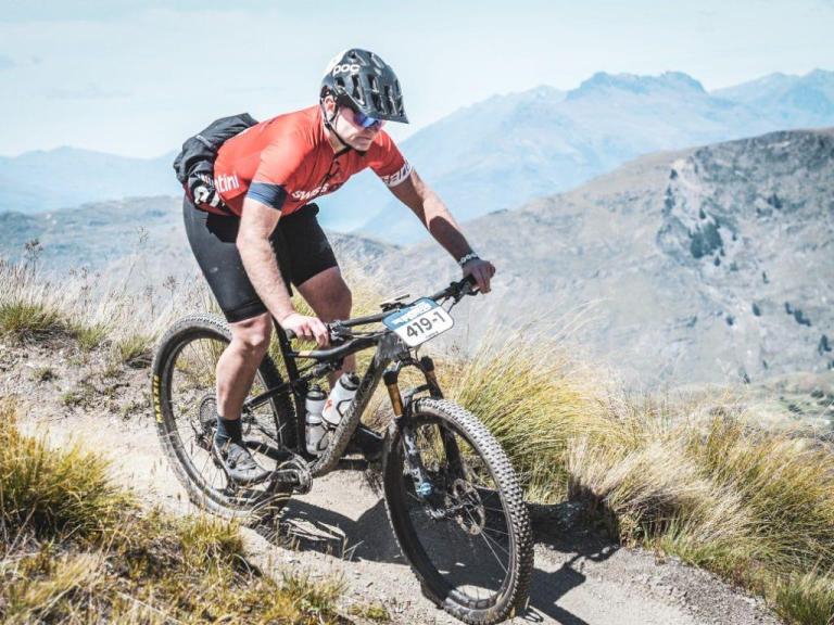 James Scharf Jr standing on his pedals biking across a small path