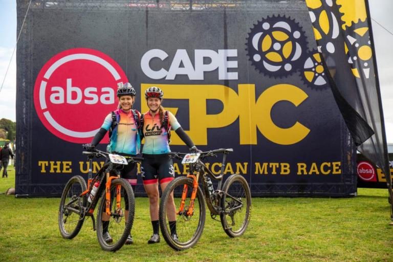 two girls posing infront of the cape epic sign