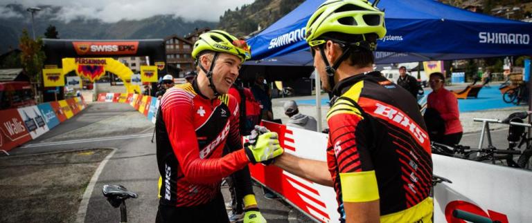 Two bikers grasping each others hands