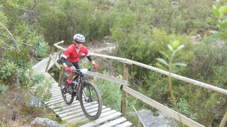 A biker heading over a wooden bridge [FNB Wines2Whales]