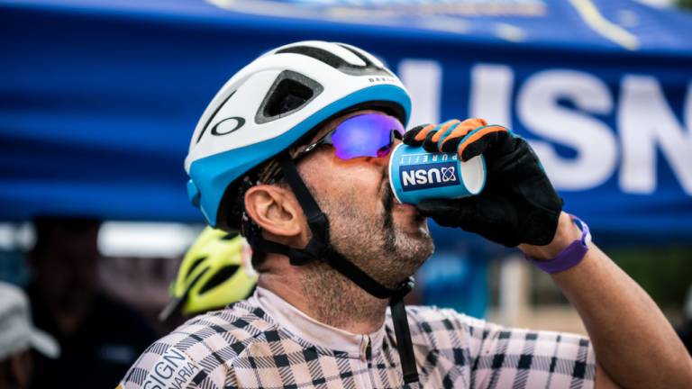 Someone drinking a small cup of USN [FNB Wines2Whales]