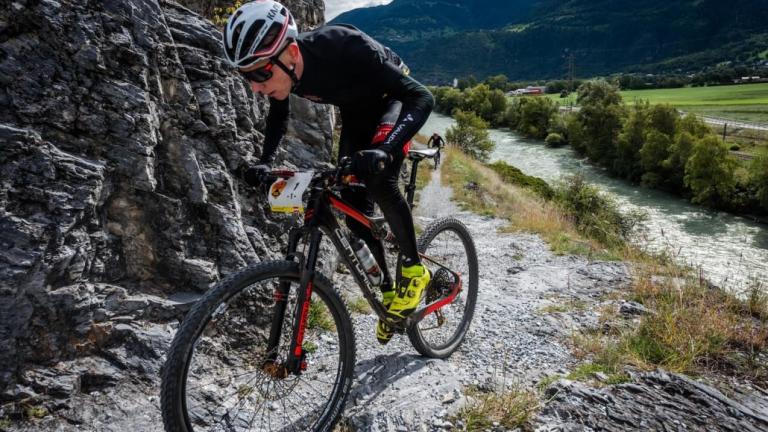 One biker struggling up a sharp incline [Swiss Epic]