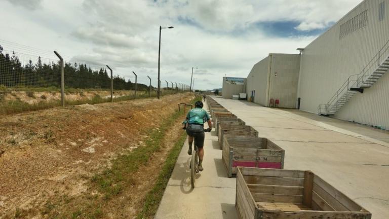 A biker riding by a ton of crates [FNB WInes2Whales]