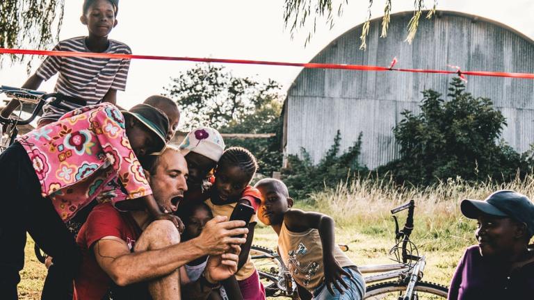 A biker showing some some children videos off of his phone [Swiss Epic]