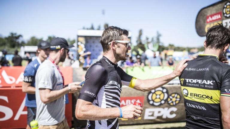 A biker putting his hand on Alban Lakata's shoulder [Absa Cape Epic]