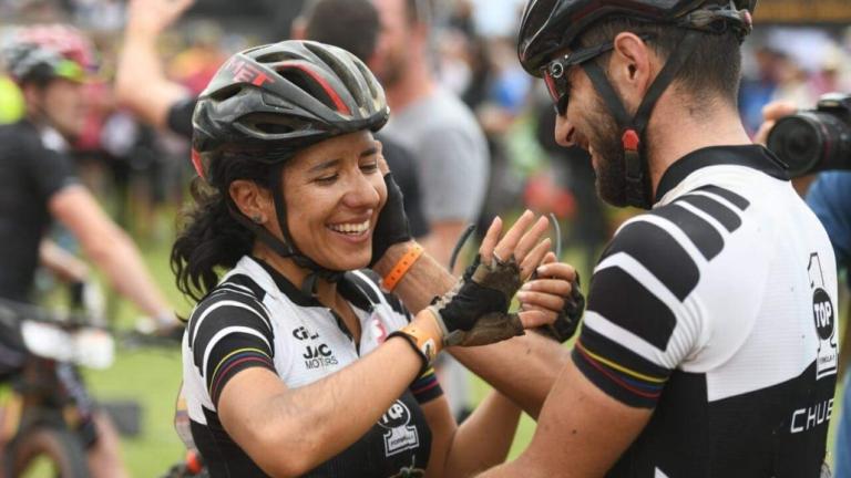 Two bikers holding hands crossing the finish line [Swiss Epic]