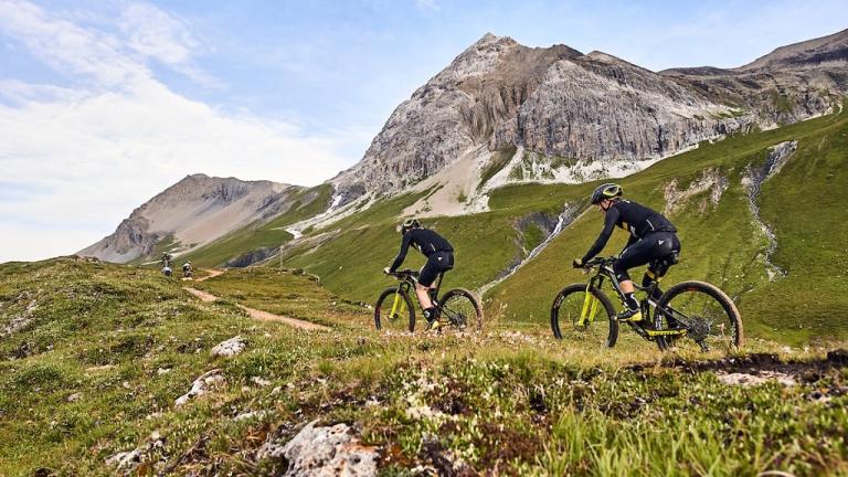 Two bikers biking against the hills of Graubünden  [Swiss Epic]