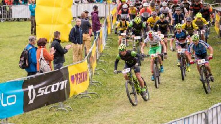 A league of bikers heading through the grassy Perskindol race  [Swiss Epic]