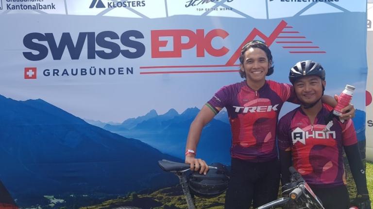 Two bikers posing in front of the Swiss Epic poster [Swiss Epic]