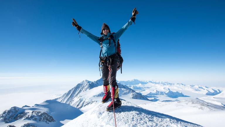 Wayne Morris with his arms outstretched on a mountain peak [Swiss Epic]