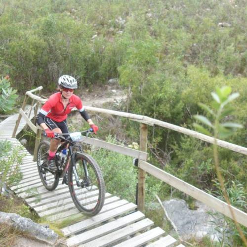 A biker heading over a wooden bridge [FNB Wines2Whales]
