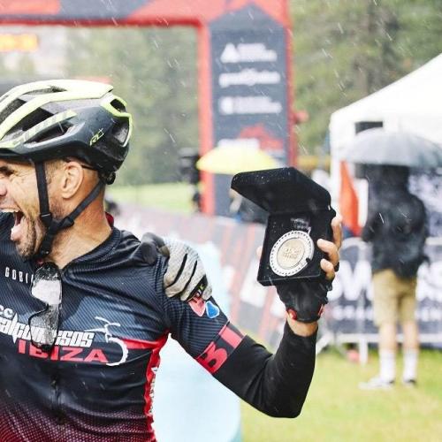 Two bikers in the rain showing off their 2020 Swiss Epic Medals [Swiss Epic]